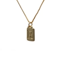 Close-up of a gold rectangle pendant necklace featuring an embossed letter R design - Letter R