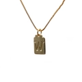 Detail of a golden rectangular pendant with an embossed letter W on a delicate box chain - Letter W