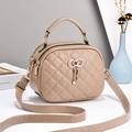 Elegant beige quilted handbag with bow metal clasp and shoulder strap in a stylish setup - Khaki