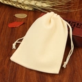Beige velvet drawstring pouch for jewelry storage on dark wood tabletop display - Beige; 5*7cm