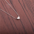 Macro shot of polished silver heart pendant on box chain over dark wood surface - Silver Heart