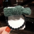 Grazioso elastico per capelli in peluche verde con fascia nera tenuto in mano per l'autunno - Linea di Punti Fiocco-Verde