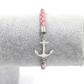 Detail of pink braided leather bracelet with silver anchor charm and metal clasp - Pink