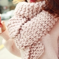 Close-up of thick light pink knitted scarf showing soft texture and warm chunky yarn weave - Pink