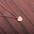 Elegant rose gold titanium steel necklace with a polished heart pendant on wood texture - Rose Gold