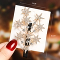 Close-up of golden star-shaped hair clip with inlaid rhinestones and duckbill grip - S198-1 Starburst Hair Clip