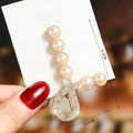 Detailed view of elegant gold pearl hair clip with rhinestones measuring 6.5cm by 4.2cm - S198-5 Streamline Pearl Bow