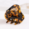 Macro detail of tortoiseshell acetate hair claw clip with glossy finish and metal spring - S136-6 Bow Amber Tortoise