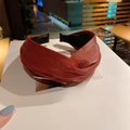 Close-up of deep red faux leather twisted headband with detailed stitching and soft padding - Burgundy