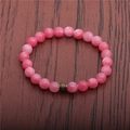 Detail view of pink gemstone bead bracelet with unique color-changing mood bead - Rhodonite