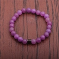 Close-up of purple beaded mood bracelet with dark brown stone cylinder on leather texture - Purple Stone