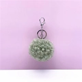 Detailed view of a soft curly plush pom-pom keychain featuring a silver lobster clasp - 1 Piece / Green