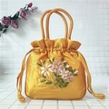 Détail du sac en satin jaune avec broderie florale en ruban et poignées circulaires - Orange