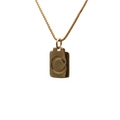 Macro shot of polished gold copper necklace featuring a rectangular letter C pendant - Letter C