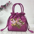 Gros plan du sac en satin violet à cordon avec broderie florale élégante et poignée - Violet Rose