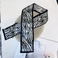 Detail of zebra print satin hair ribbon on a luxury tray for a chic fashion accessory look - Black and White Wave
