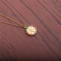 Collar con colgante de timón dorado y circonitas de colores sobre madera oscura - Cadena en O Timón