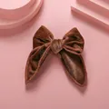 Barrette nœud en velours marron avec texture fine sur un fond rose poudré - Marron