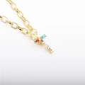 Close-up of gold plated cross pendant with vibrant multi-color zircon stones and textured link chain - Letter T
