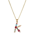 Macro shot of 18K gold letter K pendant featuring multi-color pavé set gemstones - Letter K