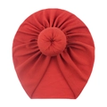 Detail of red soft fabric baby donut turban hat showing the top knot texture and material - Orange