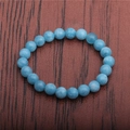 Macro shot of 8mm blue tiger eye beads on an elastic bracelet with polished finish - Blue