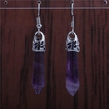 Macro shot of purple crystal hexagonal earrings with silver-toned metal hooks and settings - Purple Crystal