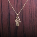 Halskette mit Hamsa-Hand-Anhänger aus goldenem Titanstahl und bösem Blick auf Holz - Silber