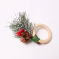 Detail eines Serviettenrings mit Tannennadeln, roten Beeren und Zapfen auf Holzring - Zeder Pinienzapfen Stil