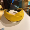 Detail of yellow PU leather headband featuring a cross knot design and fine stitching - Yellow