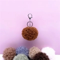 Detail showing soft curly plush pompom keychain with multi-color options - 1 Piece / Brown