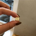 Macro shot of gold-plated dice pendant with micro-paved cubic zirconia letter G detail - Letter G / Gold