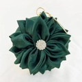 Macro shot of emerald green silk satin evening bag with layered flower petals and rhinestones - Green