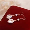 Elegant handmade baroque pearl earrings with gold wire wrapping on red velvet display - Round Baroque Pearl / White