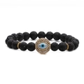 Macro shot of lava stone bead bracelet featuring a paved evil eye pendant and gold accents - Lava Stone