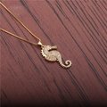 Collana con ciondolo a forma di cavalluccio marino dorato e zirconi su legno scuro - Ippocampo con catena a scatola dorata