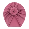 Detailed view of pink knitted baby donut hat with soft ribbed texture and top knot design - Dark Mauve