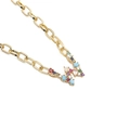 Macro view of gold chain necklace featuring a W-letter pendant with colorful gemstones - Letter V