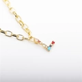 Macro view of gold letter L necklace pendant with colorful zircon stones inlay - L