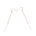 Detalle de pendientes largos de cadena en oro rosa con un acabado pulido minimalista - Oro rosa