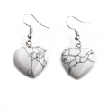 Macro shot of white heart-shaped earrings with black vein texture and metal hooks - Howlite