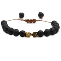 Adjustable woven lava stone bracelet with bronze arrow beads on a plain white background - Volcano Stone + Gold Arrow