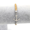 Detail of a brown braided leather anchor bracelet displayed on a grey velvet jewelry stand - Yellow