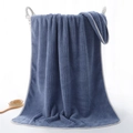 Navy blue coral fleece bath towel with waffle texture hanging on a white basket - 70x140cm / Lucky Grid/Cyan Blue