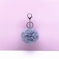 Close-up of grey curly faux fur pom-pom keychain with a shiny silver metal lobster clasp. - 1 Piece / Blue