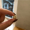 Detailed view of a gold-plated square pendant with micro-pave zircon letter S on a finger - Letter S / Gold