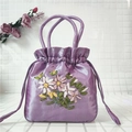 Close-up of lavender satin drawstring bag with detailed ribbon floral embroidery - Light Purple