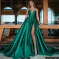 Detail van smaragdgroene satijnen jurk met diepe V-halslijn en een hoge zijsplit op de rok - S / Dresses / Groen