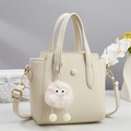 Minimalistische crème witte leren handtas met pluizige hanger en verstelbare riem - Off-wit