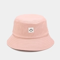 Detail of the pink cotton sun hat featuring a stitched smiley face square patch - Pink